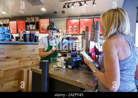 Palm Beach Gardens Florida,Starbucks Coffee,cafe,coffee house,interno,bancone,senior,donna,lavoro,barista,cliente,ordinazione,mobile,smartphone, Foto Stock