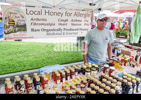 Orlando Winter Park Florida,Downtown,quartiere storico,mercato degli agricoltori,sabato settimanale all'aperto,venditore,miele locale crudo,proprietà medicinali,uomo,shopping Foto Stock