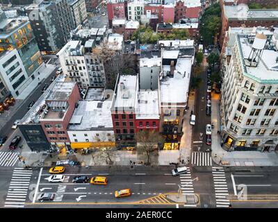 Vista aerea della città di New York Street scene con taxi la guida verso il basso Bowery passato gli edifici del quartiere Nolita di Manhattan NYC Foto Stock