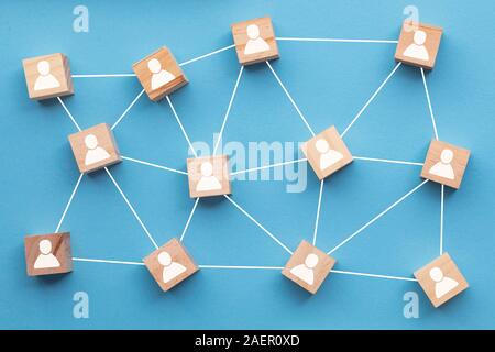 Blocchi di legno collegati tra loro su uno sfondo blu. Concetto di lavoro di squadra Foto Stock