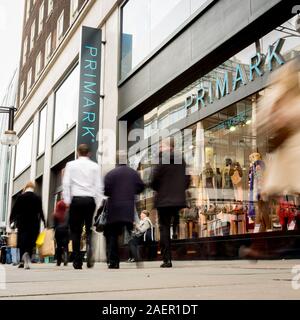 LONDON, Regno Unito - 23 novembre 2011: gli acquirenti sfocata oltrepassando il negozio di fronte al Primark store, un rivenditore di moda, a Londra, in Oxford Street. Foto Stock