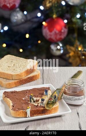 Figurine lavoratori su fetta di pane e crema di cioccolato Foto Stock