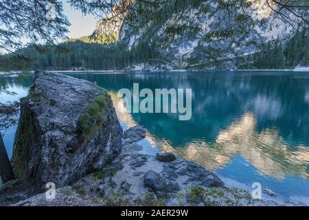 Giganteschi massi sulle rive del Lago di Braies su cui le montagne sono riflessi Foto Stock