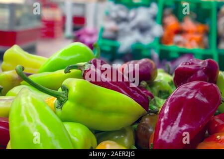 Il rosso, il verde e il giallo dei peperoni su un contatore al supermercato. Foto Stock