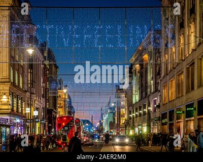 Le luci di Natale a Oxford Street, Londra con gli acquirenti. Foto Stock