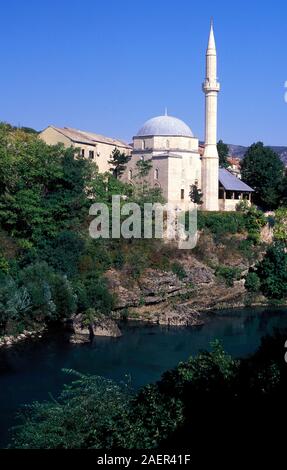 La cupola e il minareto della Koski Mehmed Pasha moschea dal fiume Neretva a Mostar, Bosnia Erzegovina Foto Stock