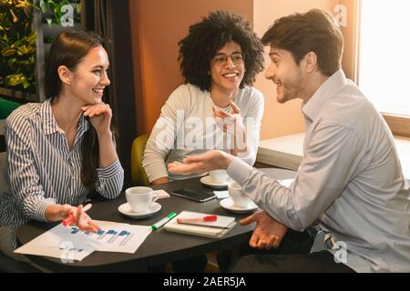 SMM team crea nuova strategia durante il pranzo di lavoro nel cafe Foto Stock