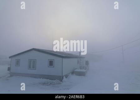 Condizioni di Blizzard in Arviat, Nunavut Canada durante il mese di dicembre. Casa quasi completamente andati in condizioni invernali nell'artico canadese Foto Stock