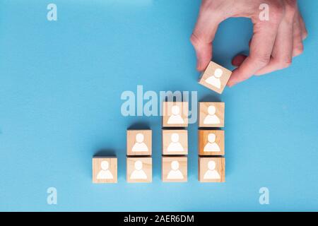 Mano aggiungendo un nuovo membro del team a un gruppo. Business management concept Foto Stock