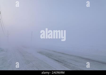 Strada di scomparire sotto condizioni di blizzard in Arviat, Nunavut Canada in condizioni invernali Foto Stock