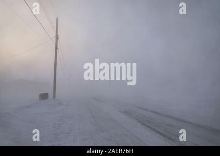 Strade e edifici scomparendo in condizioni di neve o di inverno nell'Artico canadese nella comunità di Arviat, Nunavut Canada Foto Stock