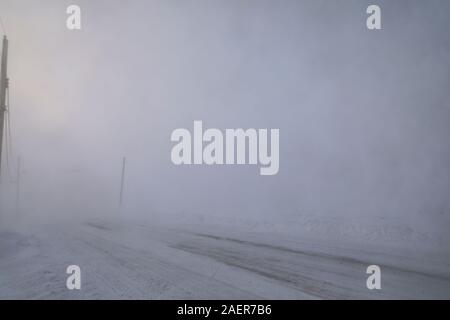 Strade e edifici scomparendo in condizioni di neve o di inverno nell'Artico canadese nella comunità di Arviat, Nunavut Canada Foto Stock