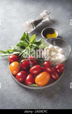 Insalata Caprese ingredienti - pomodori, formaggio e basilico. Foto Stock