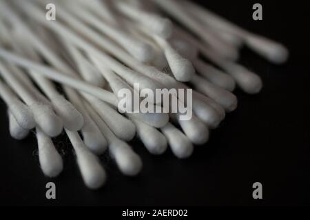 Pila di batuffoli di cotone su sfondo nero. Extreme close up e messa a fuoco selettiva dell'immagine. Foto Stock