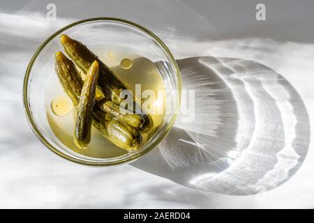 I cetrioli classificati nella ciotola di vetro con aceto e olio di oliva Foto Stock
