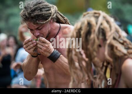 Un giovane uomo mangia una fetta di limone sul palco principale della psytrance perso teoria festival in Riomalo de Abajo Foto Stock