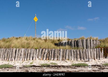 Un giallo cavo telefonico segno dietro la grande roccia Beach sull'isola di Tresco, Isole Scilly Foto Stock