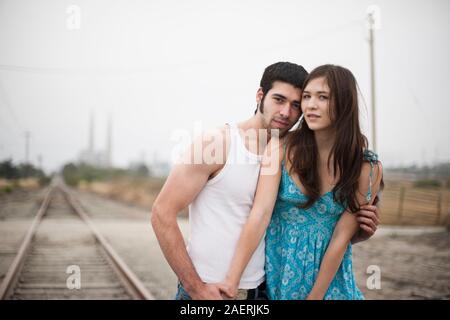 Coppia giovane costeggiata dai binari del treno Foto Stock