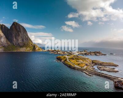 Una pesca gialla cabine in Sakrisoy nei, un piccolo villaggio di pescatori che si trova nel comune di Moskenes sulle isole Lofoten della contea del Nordland, Norvegia con una montagna mi Foto Stock