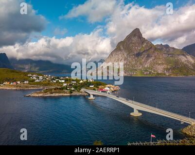 Una pesca gialla cabine in Sakrisoy nei, un piccolo villaggio di pescatori che si trova nel comune di Moskenes sulle isole Lofoten della contea del Nordland, Norvegia con una montagna mi Foto Stock