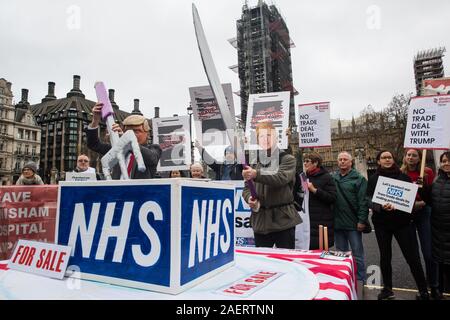 Londra, Regno Unito. 25 Novembre, 2019. Gli attivisti indossando Donald Trump e Boris Johnson maschere preparare per suddividere il NHS durante una manifestazione di protesta da attivisti da Foto Stock