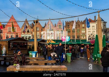 Bruges, Belgio - 5 Dicembre 2019: Persone in Natale principale piazza del mercato di Bruges Foto Stock