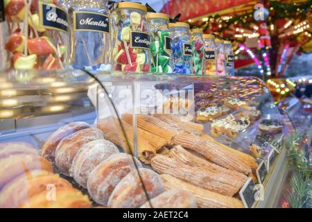 Lecca-lecca le ciambelle e torte su un contatore al mercatino di natale Foto Stock