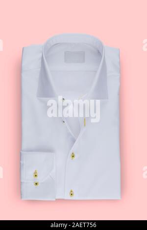 Elegante maglietta ripiegata per giovani uomini isolati su sfondo rosa Foto Stock