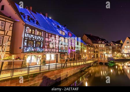 Tradizionale stile alsaziano semi-case con travi di legno e il fiume Lauch nella Petite Venise o piccola Venezia, la città vecchia di Colmar, decorata e illuminata di christma Foto Stock