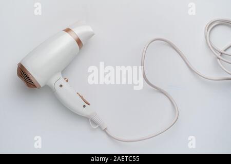 Semplice bianco asciugacapelli isolata sulla superficie di colore vista superiore Foto Stock