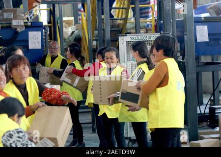 Lavoratori a EMS (Express Mail Service) centro logistico di riordinare i pacchi come doppio 11 picchi di erogazione in Huai'an City, est della Cina di provincia dello Jiangsu Foto Stock