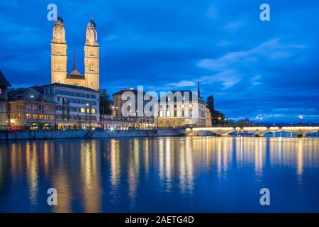 Vista sul fiume Limmat all'imbrunire, chiesa Grossmuenster e il lago di Zurigo in background, città vecchia, Zurigo, Svizzera Foto Stock