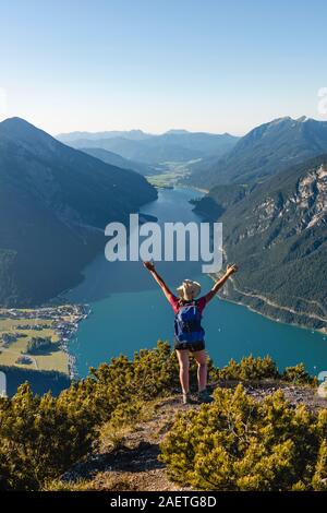 Giovane escursionista, donna guardando in lontananza, vista da Baerenkopf montagna al lago di Achen, sinistra e Seebergspitze Seekarspitze, destra Rofan Foto Stock