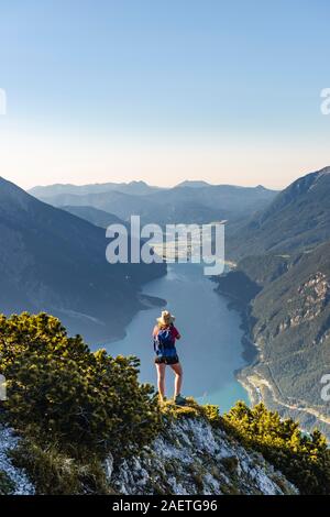 Giovane escursionista, donna guardando in lontananza, vista da Baerenkopf montagna al lago di Achen, sinistra e Seebergspitze Seekarspitze, destra Rofan Foto Stock