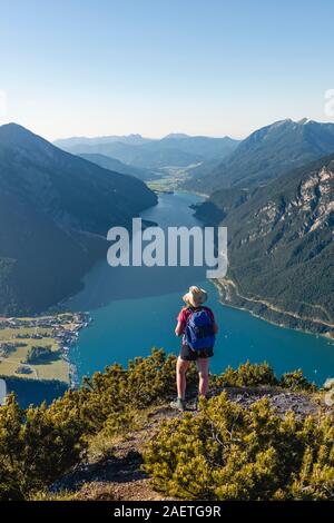Giovane escursionista, donna guardando in lontananza, vista da Baerenkopf montagna al lago di Achen, sinistra e Seebergspitze Seekarspitze, destra Rofan Foto Stock