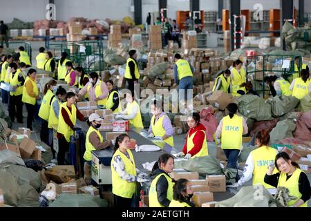 Lavoratori a EMS (Express Mail Service) centro logistico di riordinare i pacchi come doppio 11 picchi di erogazione in Huai'an City, est della Cina di provincia dello Jiangsu Foto Stock