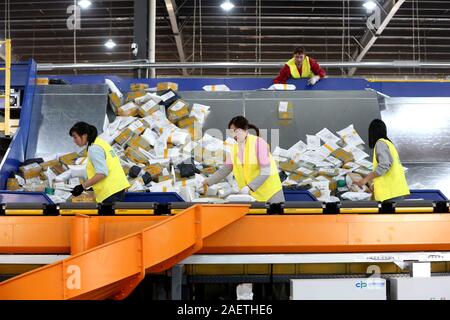 Lavoratori a EMS (Express Mail Service) centro logistico di riordinare i pacchi come doppio 11 picchi di erogazione in Huai'an City, est della Cina di provincia dello Jiangsu Foto Stock