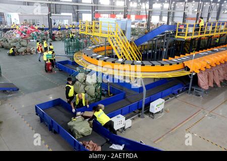 Lavoratori a EMS (Express Mail Service) centro logistico di riordinare i pacchi come doppio 11 picchi di erogazione in Huai'an City, est della Cina di provincia dello Jiangsu Foto Stock