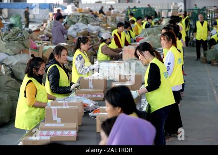 Lavoratori a EMS (Express Mail Service) centro logistico di riordinare i pacchi come doppio 11 picchi di erogazione in Huai'an City, est della Cina di provincia dello Jiangsu Foto Stock