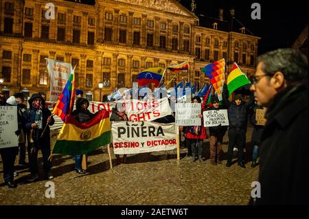 Amsterdam, Paesi Bassi. Decimo Dec, 2019. I manifestanti con cartelli e bandiere durante il mese di marzo.internazionale di diritti umani giorno, diverse piattaforme di Latina ha organizzato una marcia attraverso le strade del centro di Amsterdam per protestare contro le violazioni dei diritti umani in America Latina. Il mese di marzo ha iniziato a Waterlooplein a Dam Square dove le luci per le vittime sono stati accesi. Credito: SOPA Immagini limitata/Alamy Live News Foto Stock