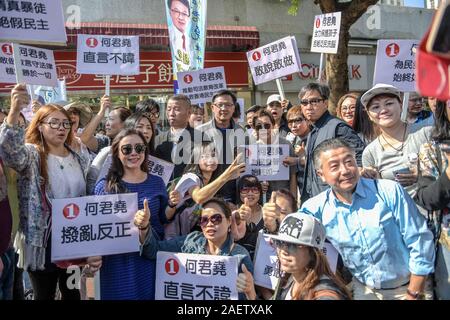 I cittadini locali prendere foto con Hong Kong giurista e politico Junius Kwan-yiu Ho, medio, al suo evento promozionale dopo che egli è stato pugnalato a Hong Kong S Foto Stock