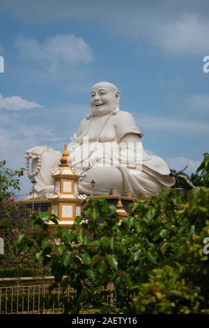 Una gigantesca statua del ridere Budai monaco a Vinh Trang pagoda vicino a My Tho, Vietnam Foto Stock