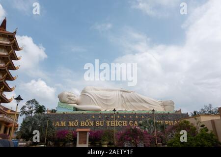 Una gigantesca statua di un sdraiato Buddha a Vinh Trang pagoda nel Vietnam del sud nei pressi di My Tho Foto Stock
