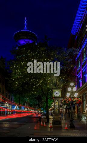 Vancouver, Canada - Luglio 09, 2019: semaforo sentieri dopo il tramonto dal vapore orologio in Gastown con il Vancouver Lookout Tower in background Foto Stock