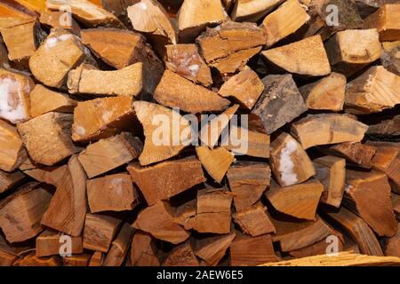 Un woodpile disteso in una capanna di legno in un villaggio russo. Il bianco della neve sulla legna da ardere Foto Stock