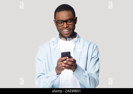 Gioioso sorridente americano africano giovane giocando online gioco. Foto Stock