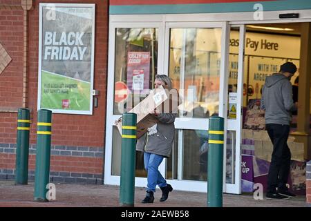 29/11/2019. Solihull, Regno Unito. Una shopper lascia un ramo di Argos con acquisti sul Venerdì nero a retail park a Solihull. Foto Stock