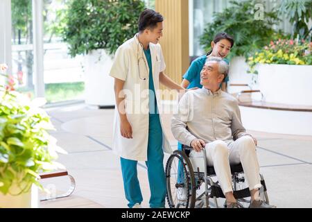 Giovane medico a parlare con il paziente in casa di cura Foto Stock