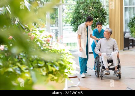 Giovane medico a parlare con il paziente in casa di cura Foto Stock