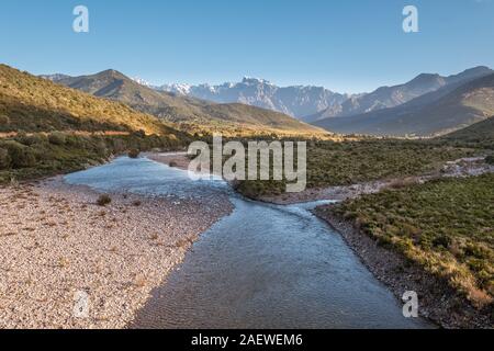 Le acque cristalline del fiume di fango vicino a Galeria in Corsica con la neve montagna ricoperte di Paglia Orba a distanza Foto Stock